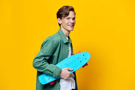 portrait of a happy man with a blue skateboard in his hands