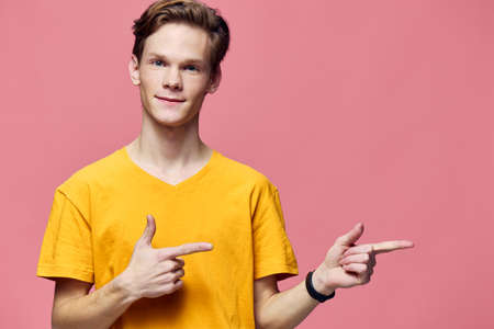 cute guy in yellow t-shirt posing showing finger gestures