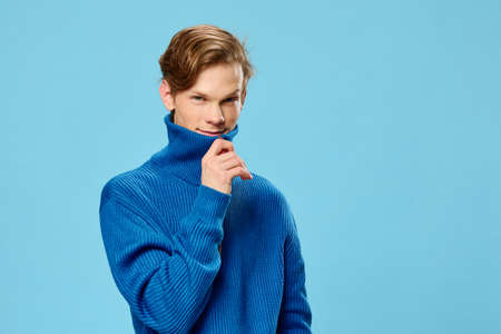 nice. cute guy zips up a blue turtleneck sweaterの写真素材