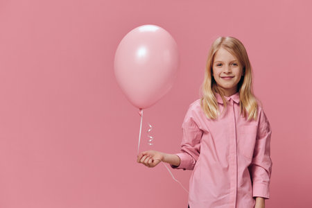 horizontal portrait of a girl in a pink shirt on a pink background with a pink balloon in her hand