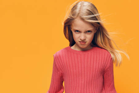 beautiful, cute, happy girl fool standing on a yellow background brightly expressing emotions