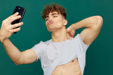 a handsome, sexy man takes pictures of his perfect abs on his phoneの写真素材