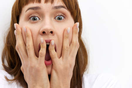 a close horizontal studio photograph of an alarmed, frightened woman with red hair, screaming loudly...