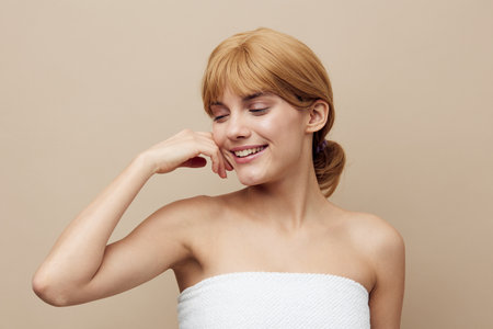a pleasant, relaxed, attractive woman stands on a beige background and closes her eyes with pleasure...