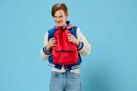 guy student with a red backpack dressed backwardsの写真素材