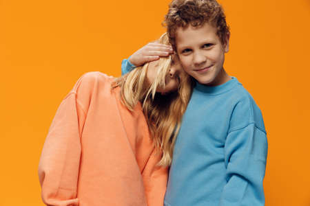 beautiful, cute children, brother and sister stand on a blue background hugging each other. Themes of relationships and friendship between childrenの写真素材