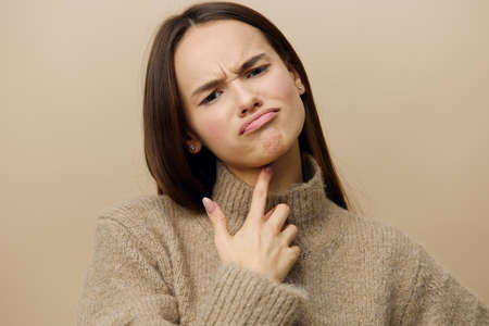 a close photo of a sad, upset young woman frowning and lowering the corners of her lips down,...