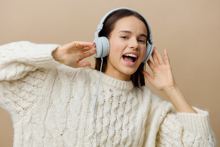 close horizontal photo of a woman in a white sweater listening to music in her wired headphones...