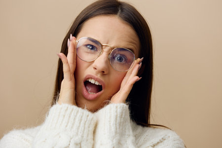 an emotional, funny, playful woman stands with her mouth wide open in surprise on a beige background...