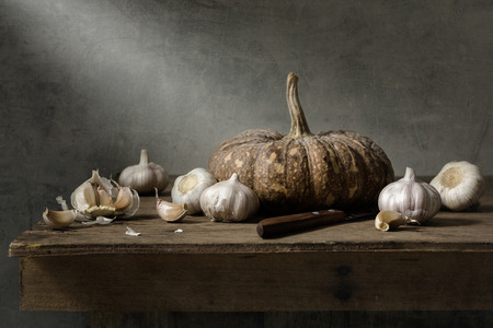 Still life with garlics and pumpkin on wood tableの写真素材