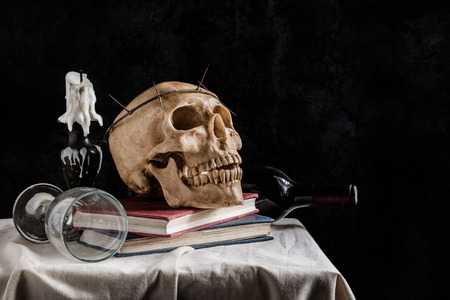 Still life with skull, book, vine glass, vine bottle and candleの写真素材