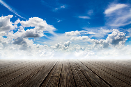 Soft focused concept image with wooden floor with blue sky and clouds backgroundの写真素材