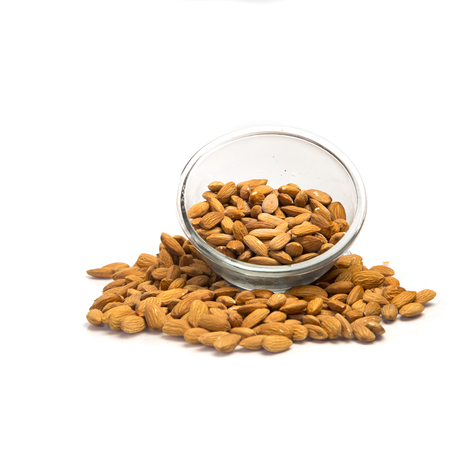 Almond heap and almond in bowl on white background.の写真素材
