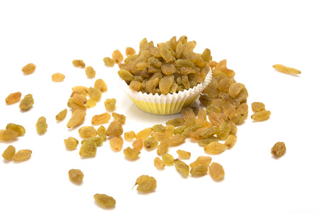 Golden dry raisins in bowl on white background.の写真素材