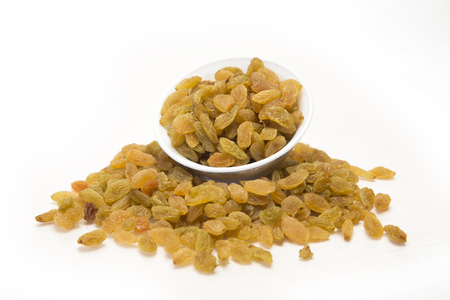 Golden raisins in bowl. Isolated on white background.の写真素材
