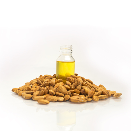 Almonds heap with almond oil in bottle.の写真素材
