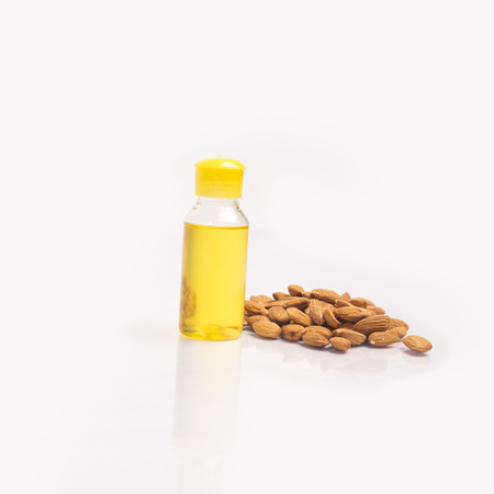 Pile of almonds and almonds oil. Isolated on white background.の写真素材