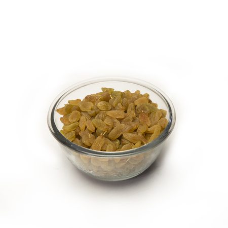 Pile of raisins in glass bowl on white background.の写真素材