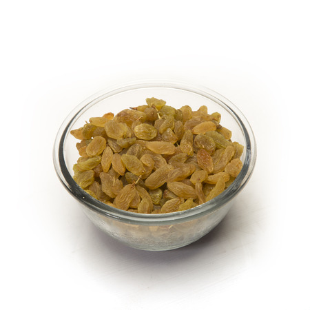 Raisins in glass bowl. Isolated on white background.の写真素材