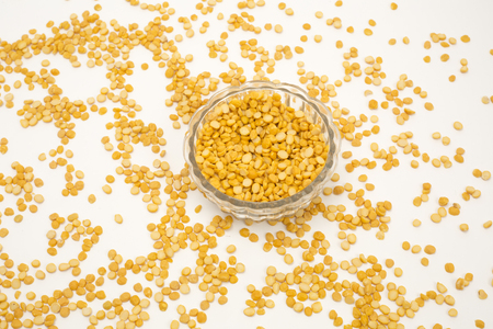 Yellow split peas in transparent bowl isolated on white backgroundの写真素材