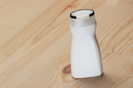 PACKAGING: White  beauty products/cosmetics bottle/shampoo bottle on wooden background. Mock-up template ready for design.の写真素材