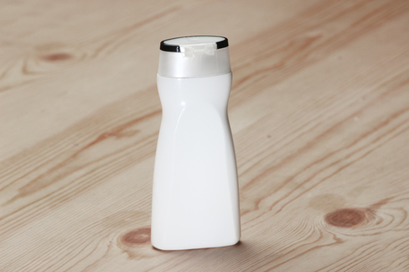VECTOR PACKAGING: White  beauty products/cosmetics bottle on wooden background. Mock-up template ready for design.の写真素材