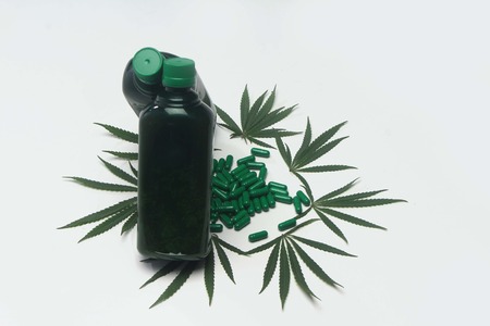 Decoration of marijuana leaves, two bottle together and Ayurveda tabletsの写真素材