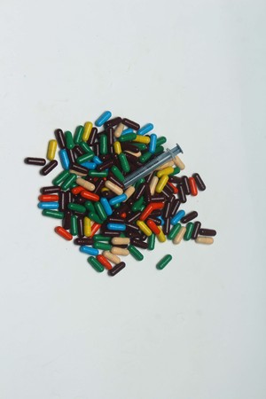 Ayurvedic colorful vitamin capsule with injection syringe. Isolated on white background.の写真素材