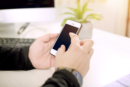 Young man is using phone in hand.の写真素材