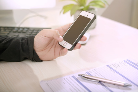 Man is holding phone  in one hand.