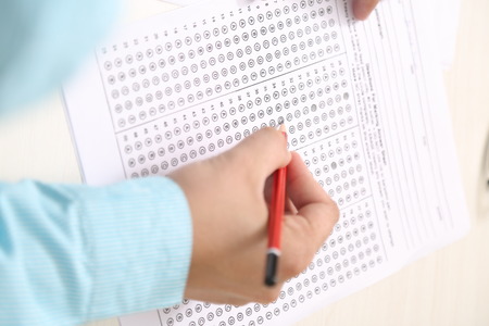 Man is filling OMR sheet with pencil.の写真素材