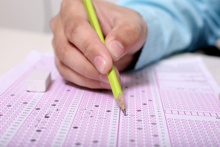 Picture of man is filling OMR sheet with pencil. Portrait of eraser on the OMR sheet.の写真素材