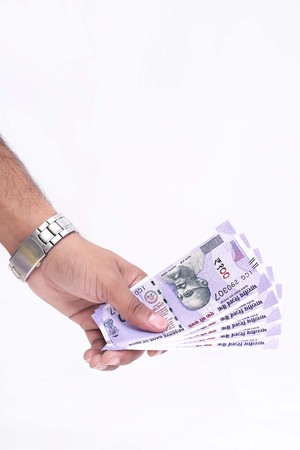 Indian one hundred rupee notes in hand. Isolated on the white background.の写真素材