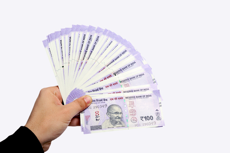 Hand showing spread of new purple notes of Indian currency . Isolated on the white background.