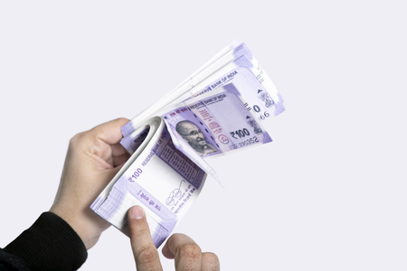 Picture of hand with new Indian currency notes. Isolated on the white background.