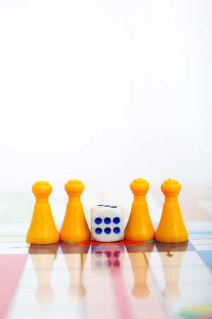 Portrait of yellow tokens with dice on the ludo board game.