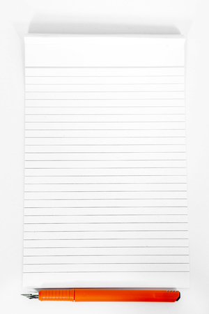 Picture of notepad with orange pen. Isolated on the white background.の写真素材