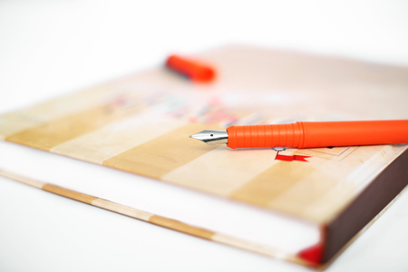 Picture of pen on the closed diary. Isolated on the white background.の写真素材