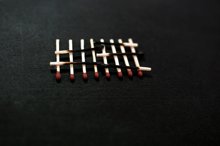 Photo of burnt matchstick and red head matchstick. Isolated on the black background.の写真素材