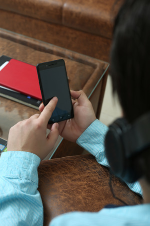 Picture of man is using smartphone in hand and listening music with headphone .の写真素材