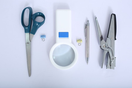 Picture of pen,stapler,scissor,paper clip and magnifying glass. Isolated on the white background.