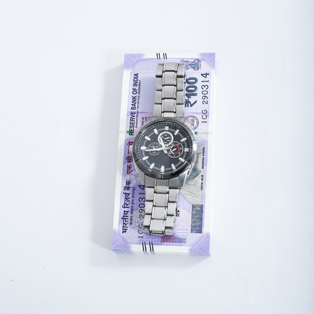 Picture of new 100 rupees note with watch. Isolated on the white background.の写真素材