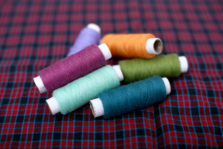 Picture of multi colored sewing thread on the cloth.