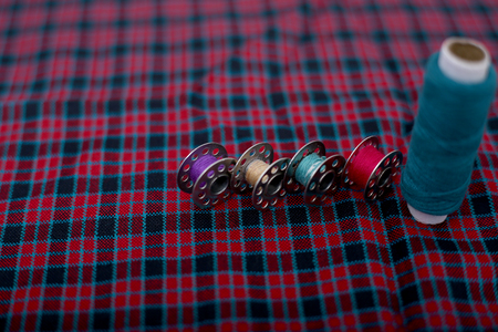 Photo of blue sewing thread and bobbins on the cloth.の写真素材