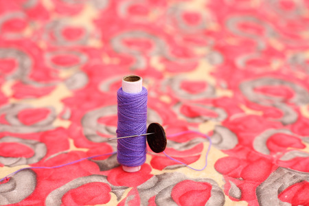 Picture of purple sewing thread, needle and button. Isolated on the colorful background.の写真素材
