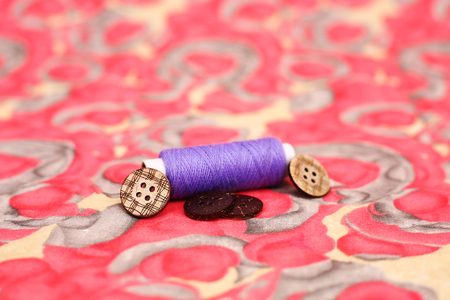 Picture of one sewing thread and button. Isolated on the colorful background.