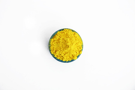 Yellow gulal color in bowl for holi festival. Isolated on the white background.