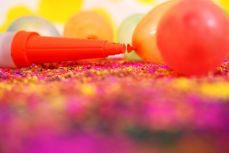 Picture of water balloons and pichkari for holi fun. Isolated on the colorful background.の写真素材