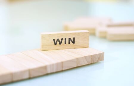 Win word written on wood block. Win text on wooden table for your design, concept.の写真素材