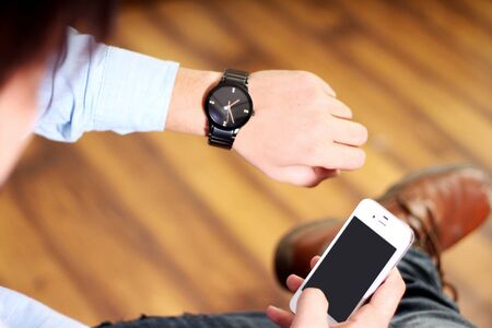 Man working on mobile and wear hand watch. Isolated on white background.